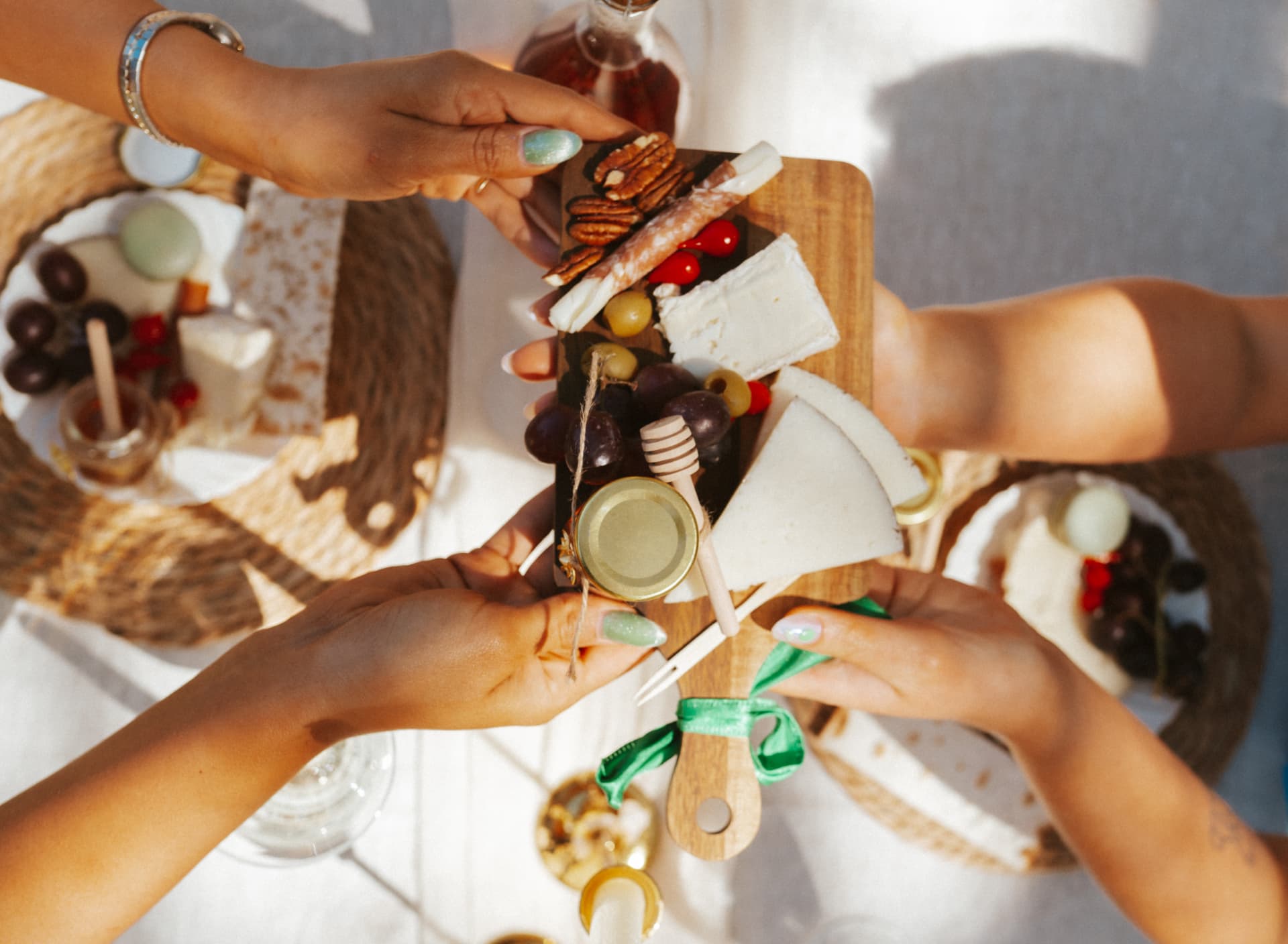 Friends holding a finished charcuterie board together over the table