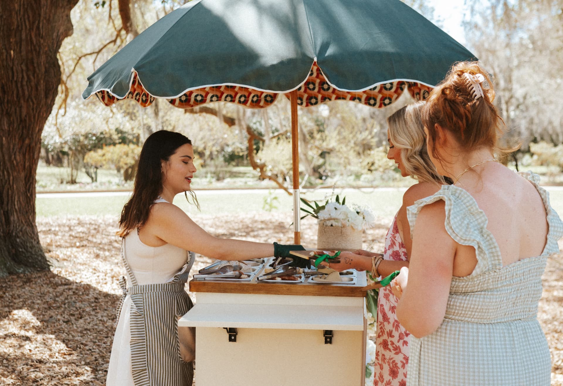 An attendant serving guests from The Perfect Pear charcuterie cart