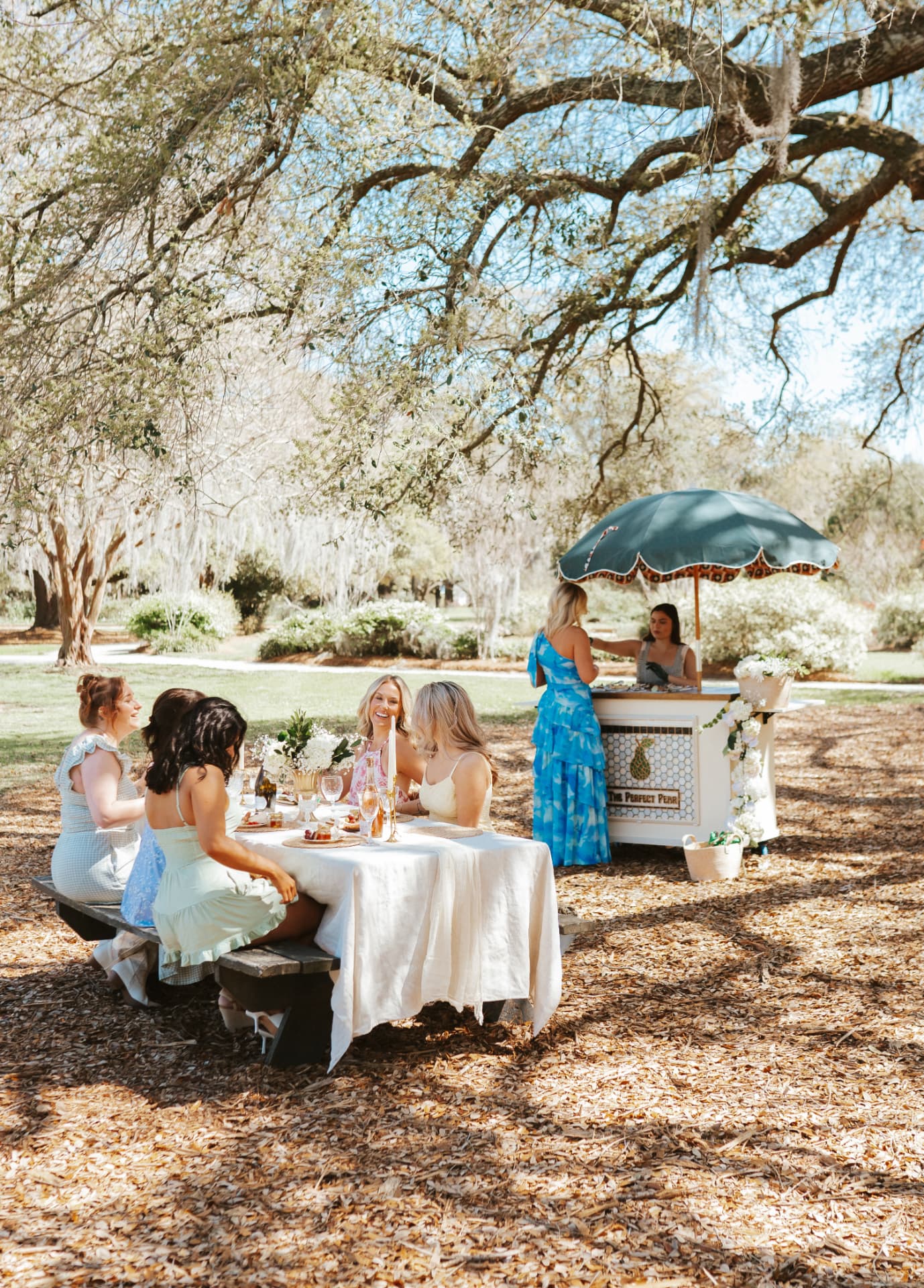 Friends enjoying an outdoor gathering with The Perfect Pear cart